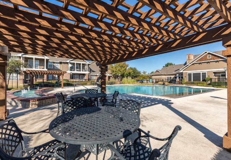 Swimming Pool with Tanning Deck, wooden pergola, and picnic tables and chairs